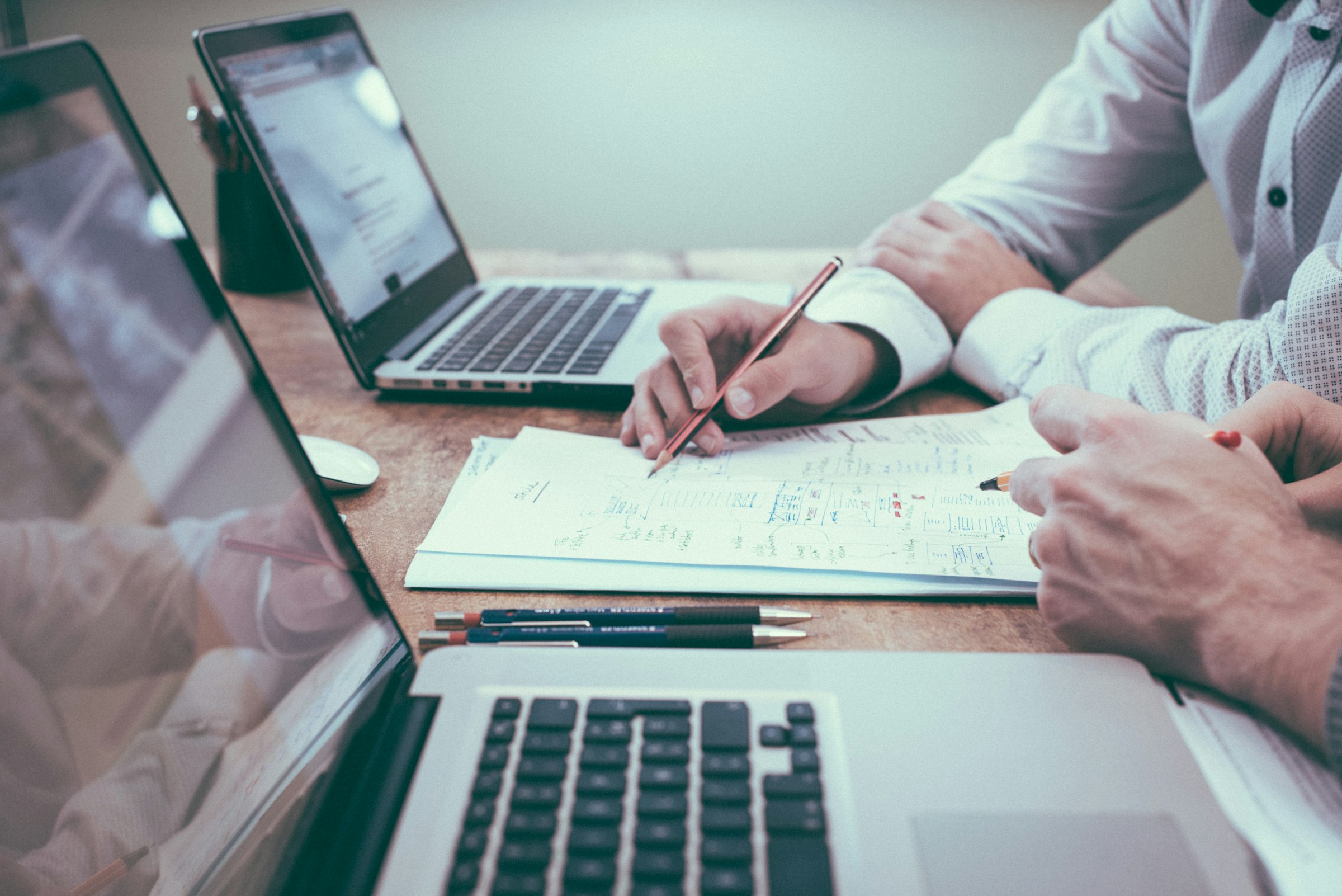 Hands working at an open laptop with documents — the way most of our clients actually file.